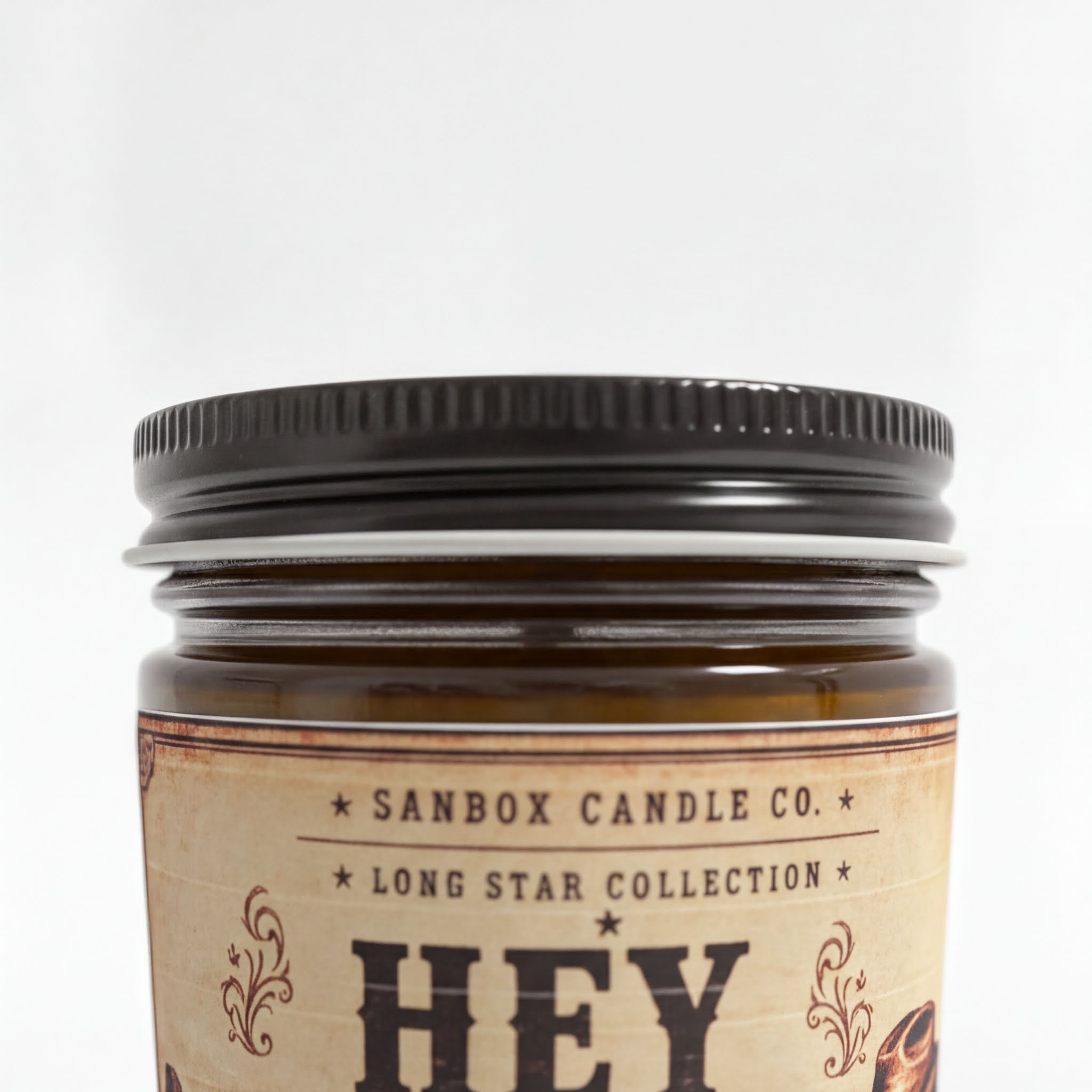 a close-up of a jar with a black lid, featuring a label with decorative text and a star symbol.