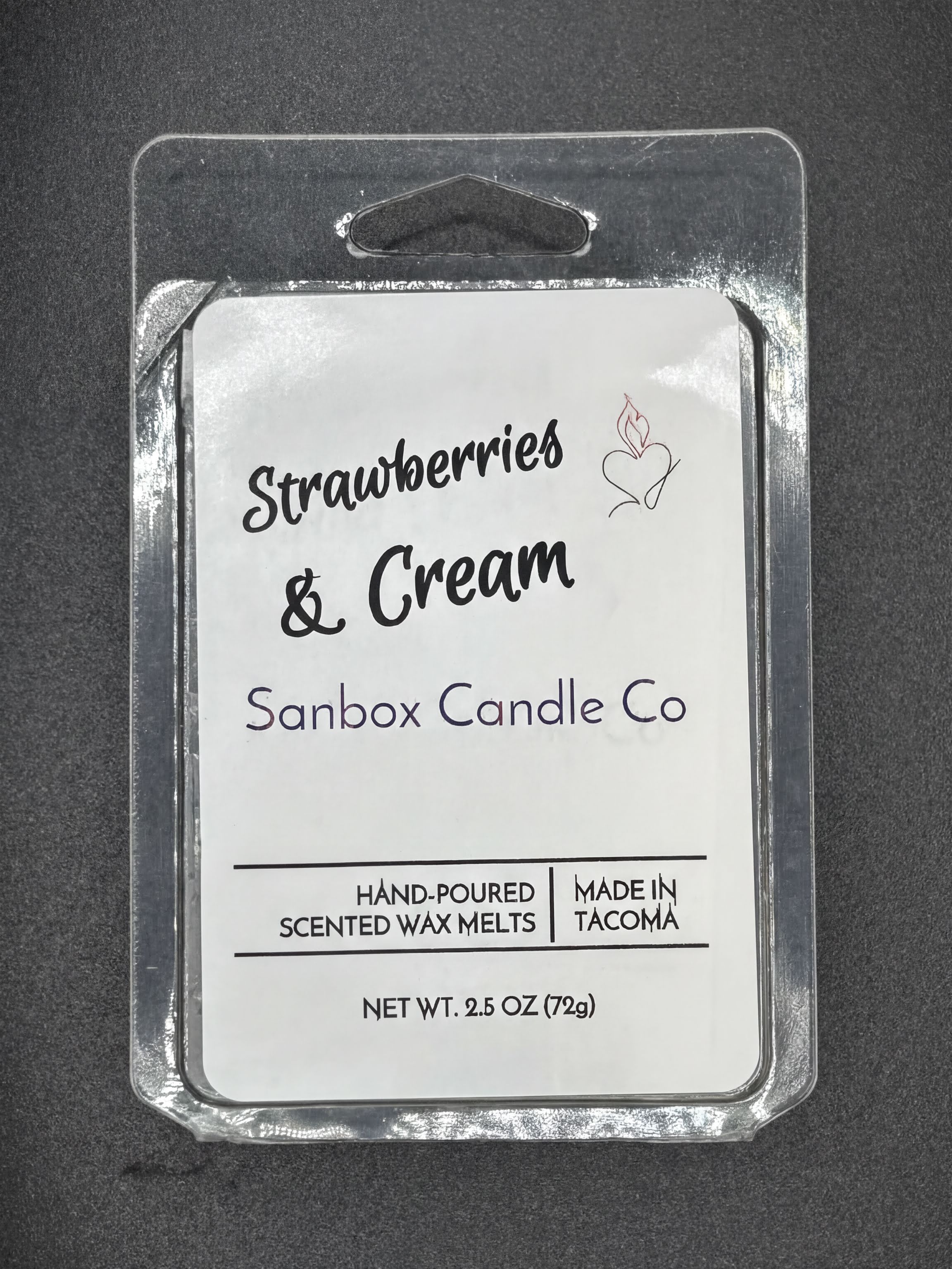Strawberries & Cream scented wax melts in plastic clamshell packaging on gray background