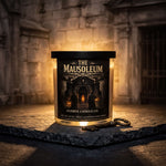 A candle labeled "The Mausoleum" sits on a stone surface, with a key and a stone wall in the background.