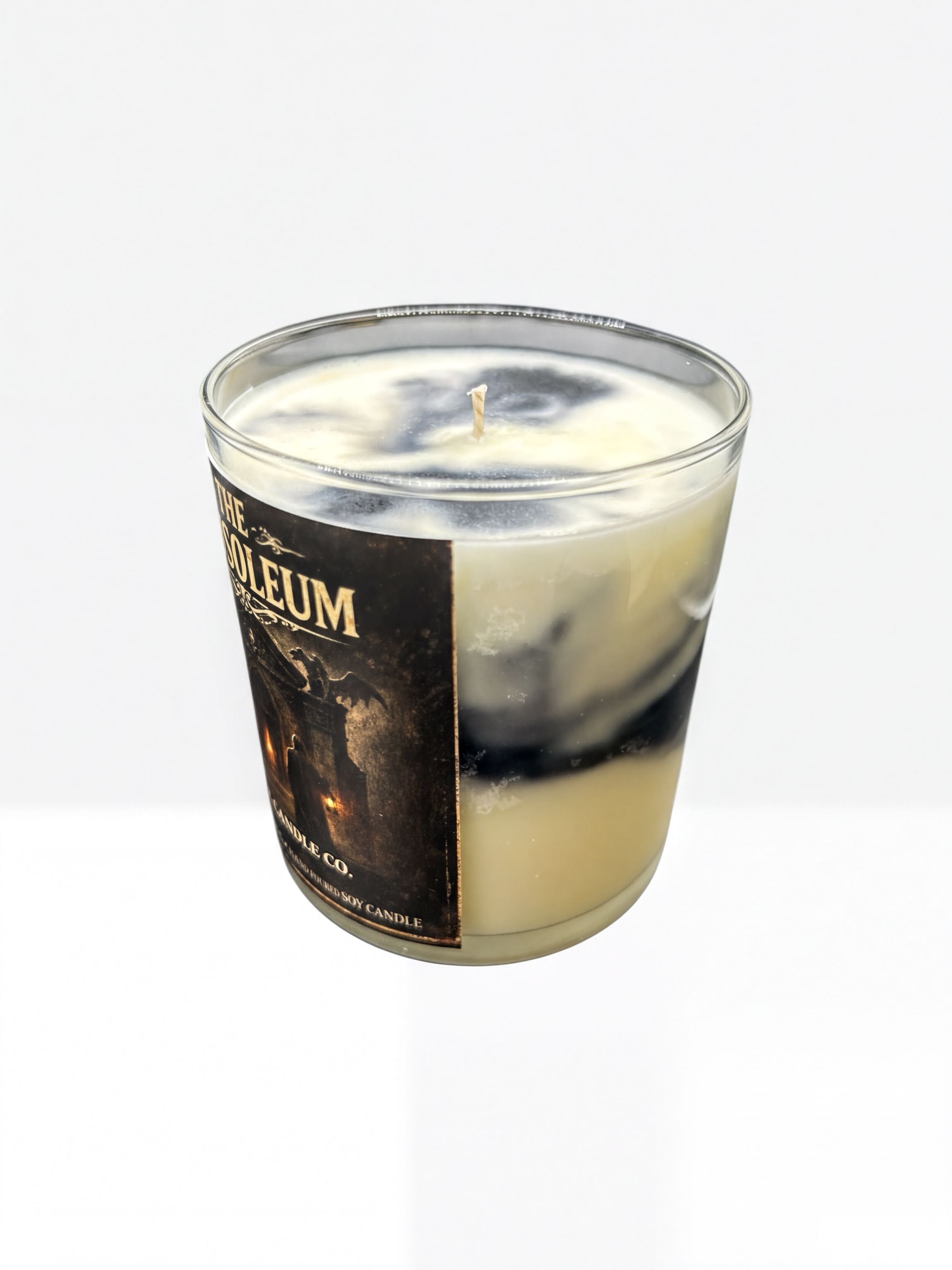A glass candle holder with a candle inside, set against a plain white background.