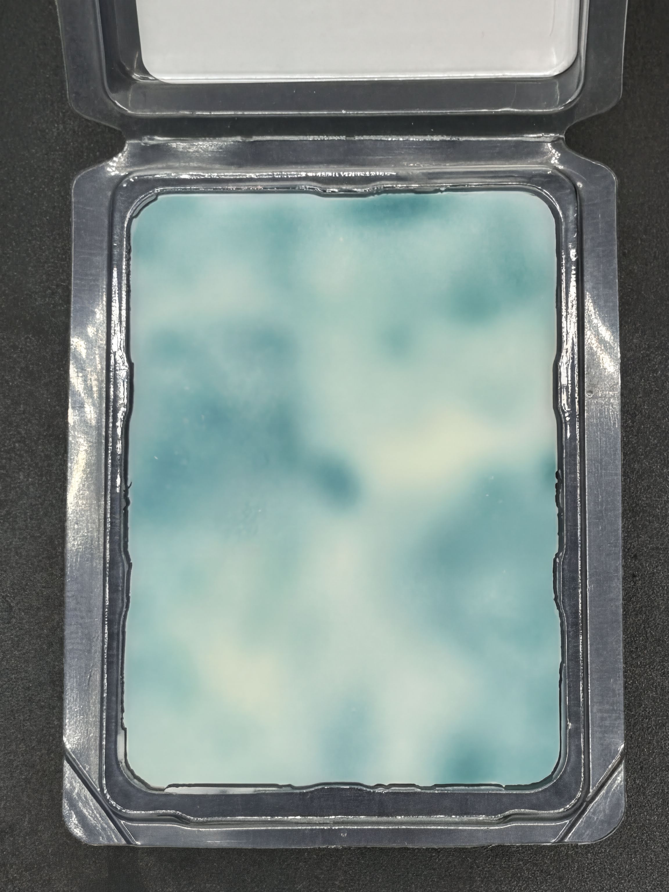 Blue and white marbled soy wax melt in clear plastic clamshell packaging