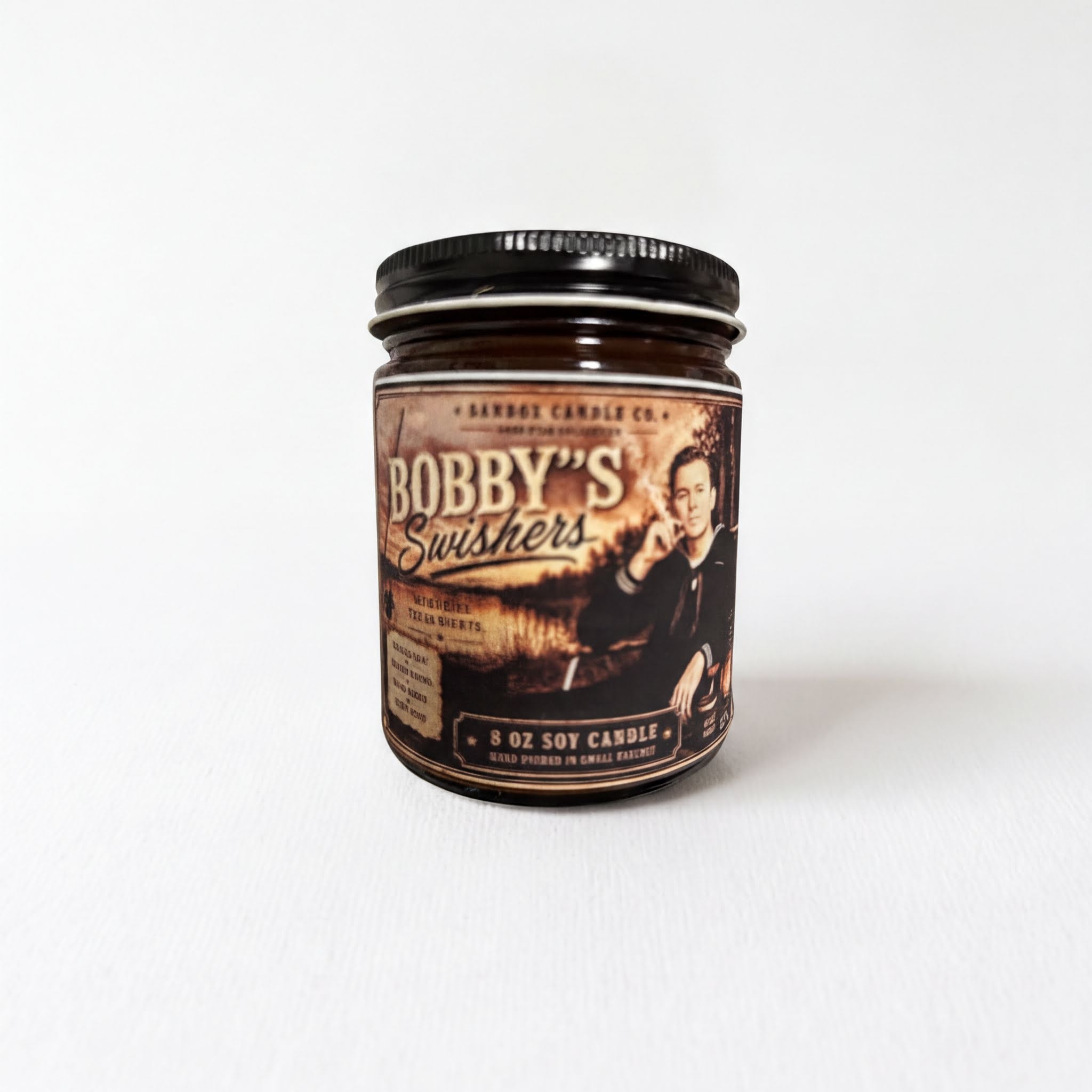 A jar of candle labeled "Bobby's Swishers" with a picture of a man on the label.