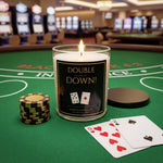 a candle labeled "DOUBLE DOWN!" placed on a green felt table, surrounded by poker chips and playing cards, suggesting a casino or poker-themed setting.