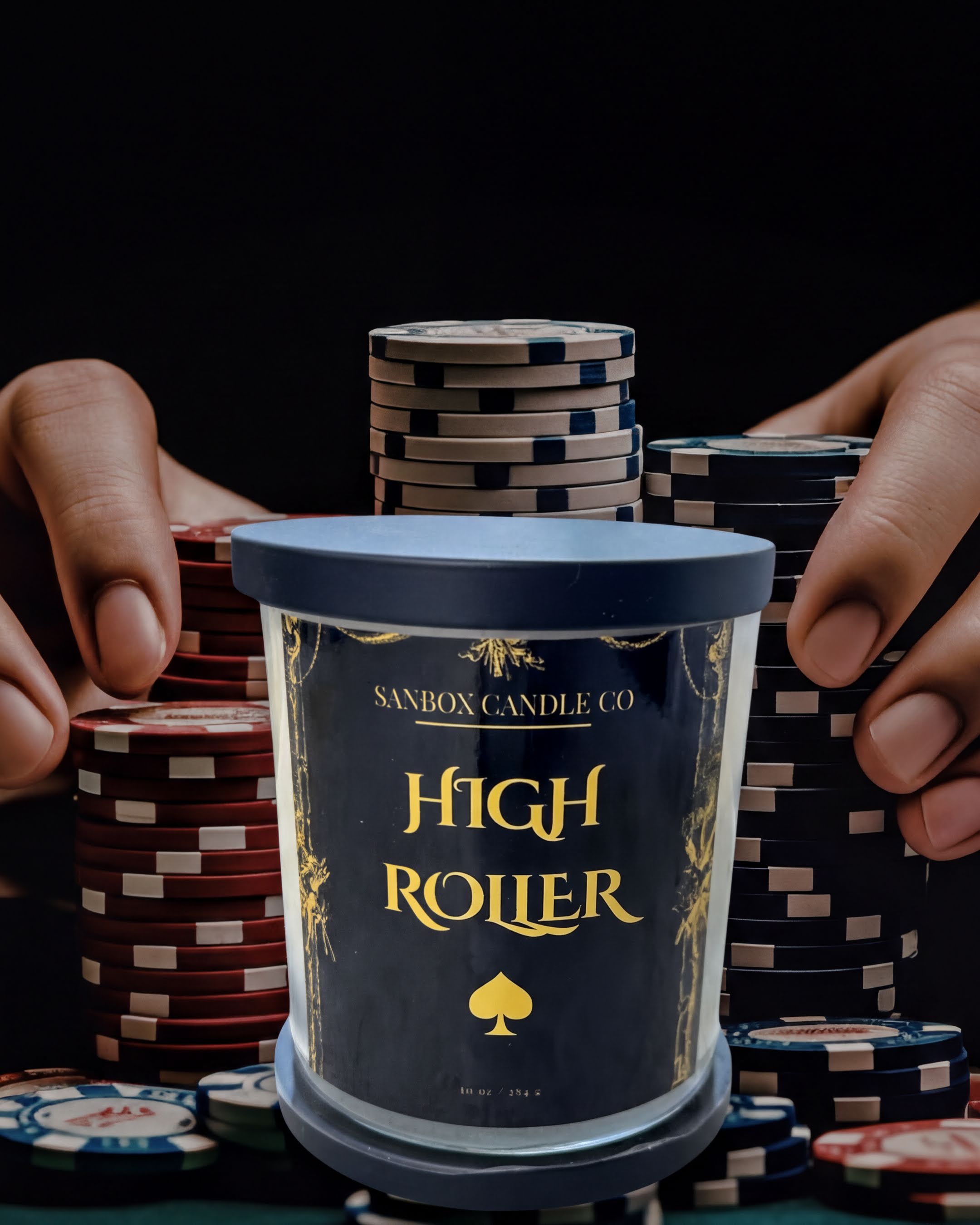 A hand holding a candle labeled "High Roller" in front of a stack of poker chips.