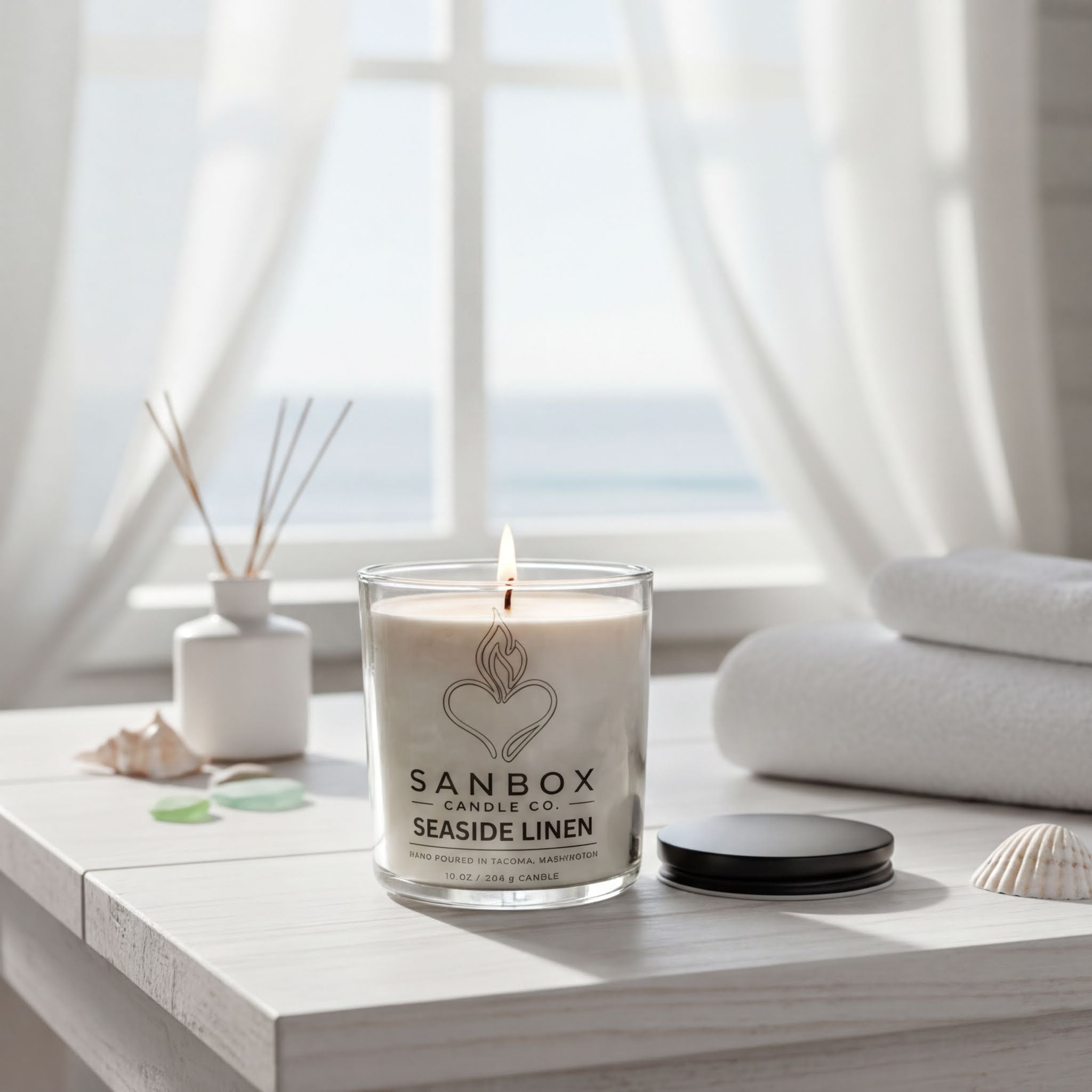 a candle on a table with a view of the ocean through a window.