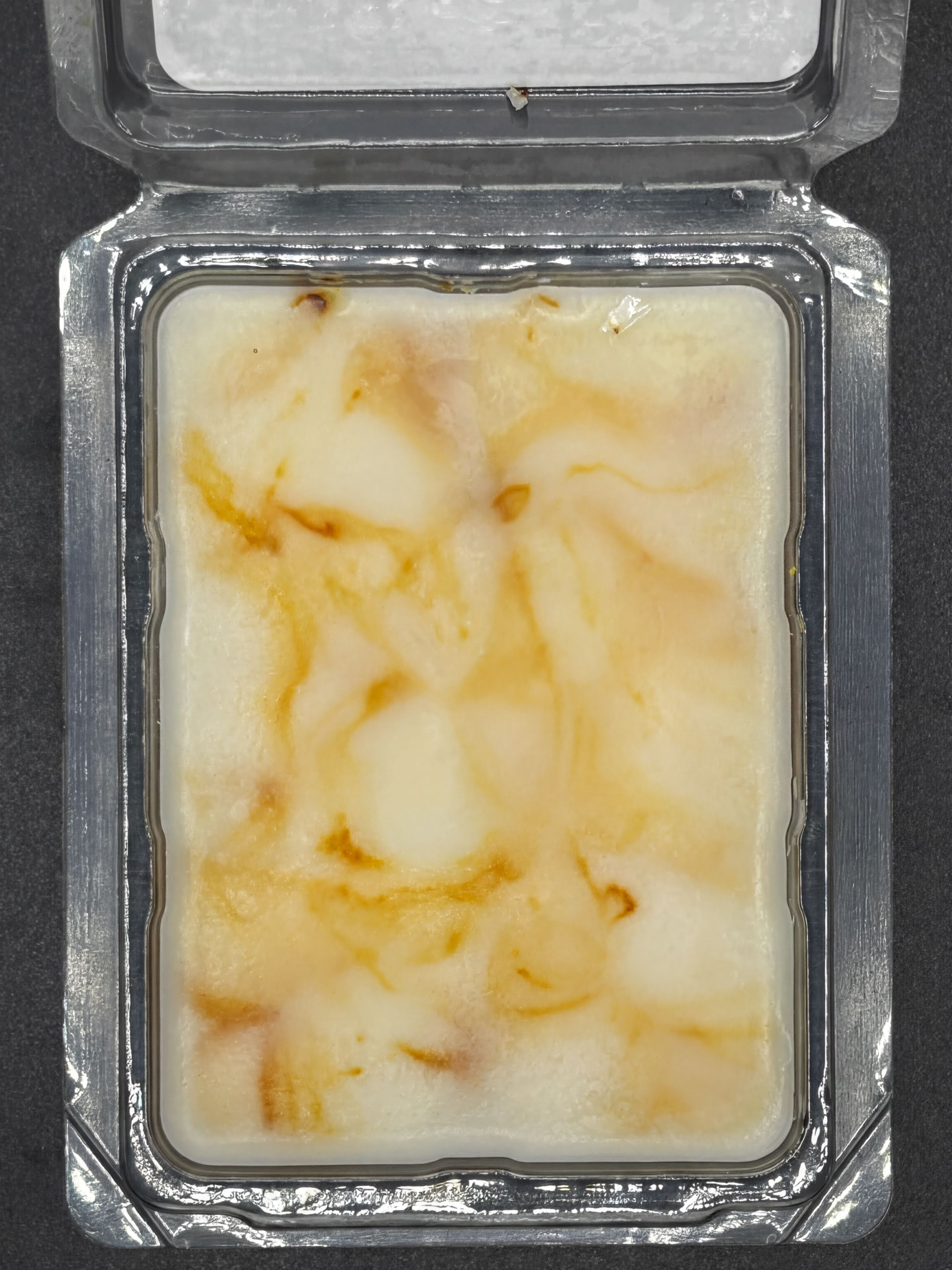 Hand-poured soy wax melt in clamshell packaging with creamy and brown marbled swirls