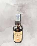 A bottle of Butterscotch Bourbon room spray against a textured gray background.