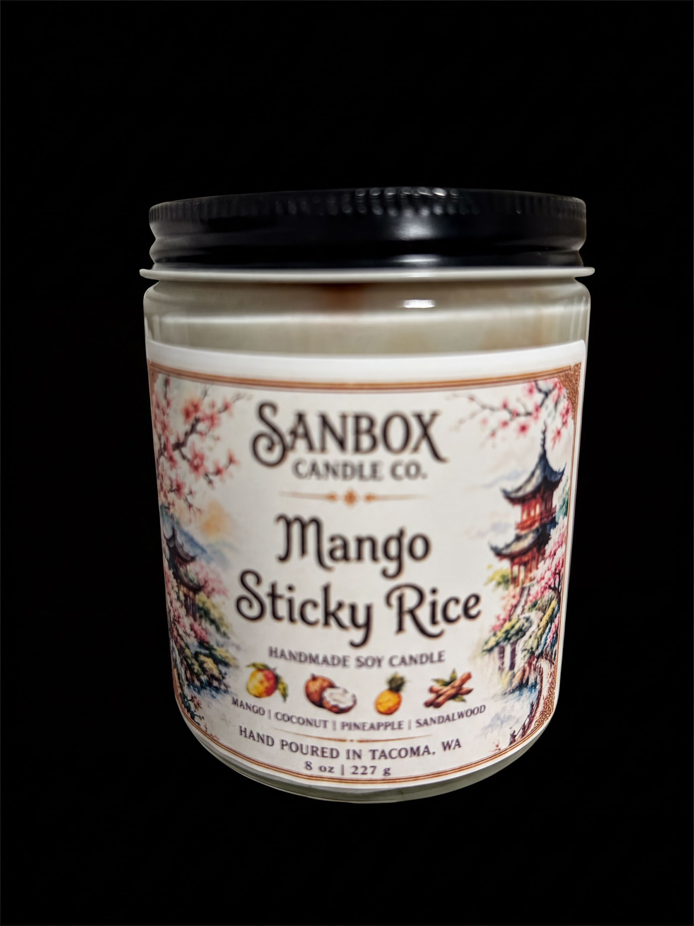 a candle in a jar with a label that reads "Mango Sticky Rice".