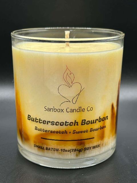 10 ounce Butterscotch Bourbon Candle without lid on a dark background from Sanbox Candle Co