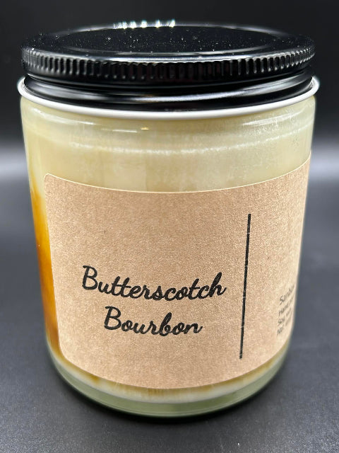 8 ounce Butterscotch Bourbon Candle with lid on a dark background from Sandbox Candle Co