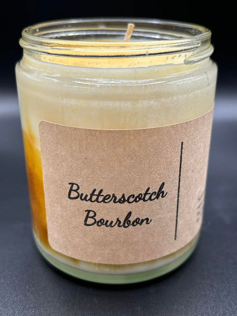 8 ounce Butterscotch Bourbon Candle without lid on a dark background.