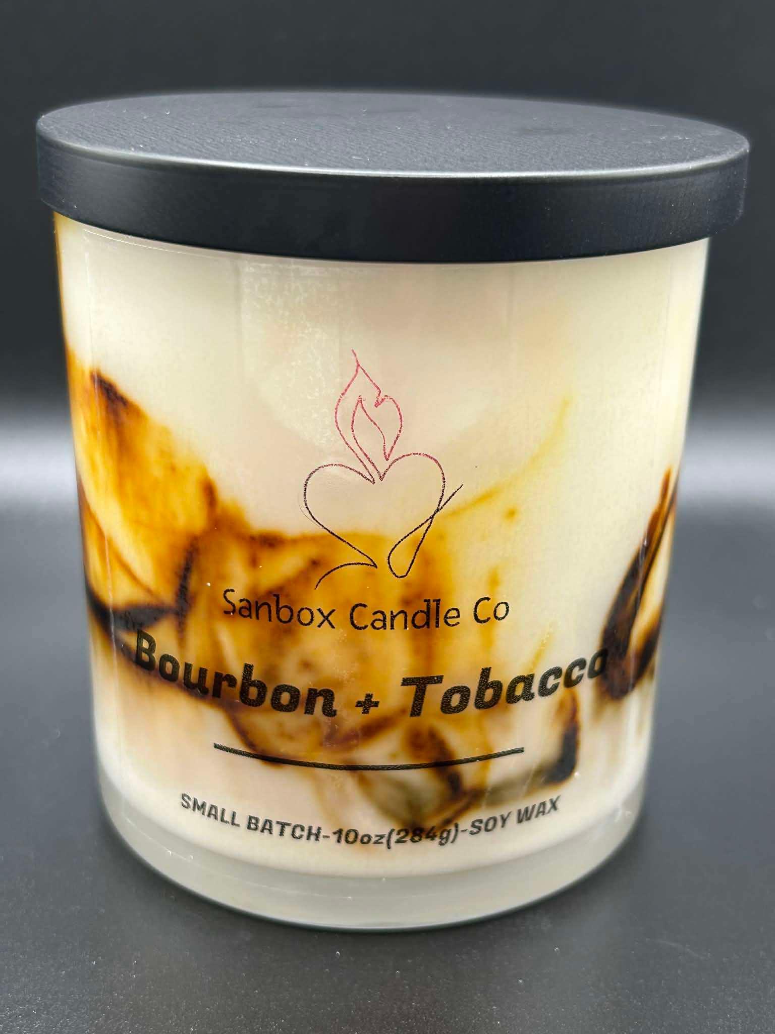 10oz Bourbon and Tobacco scented soy candle in a marbled glass jar with black lid