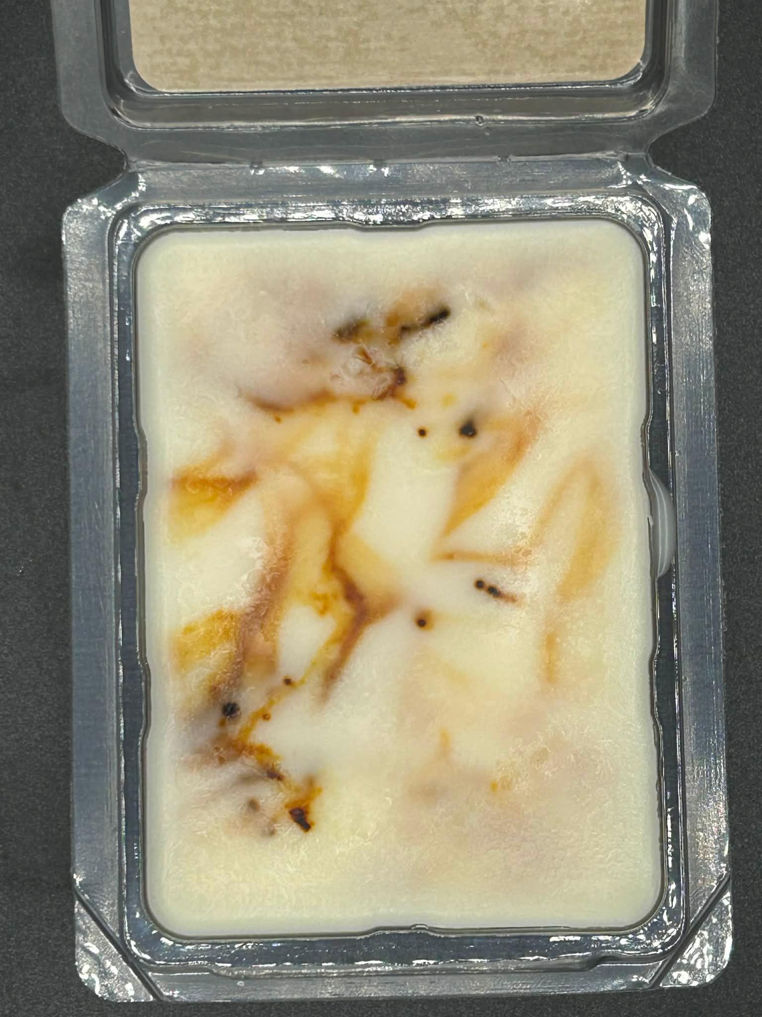 Hand-poured wax melt with marbled brown and white swirls in a plastic clamshell package