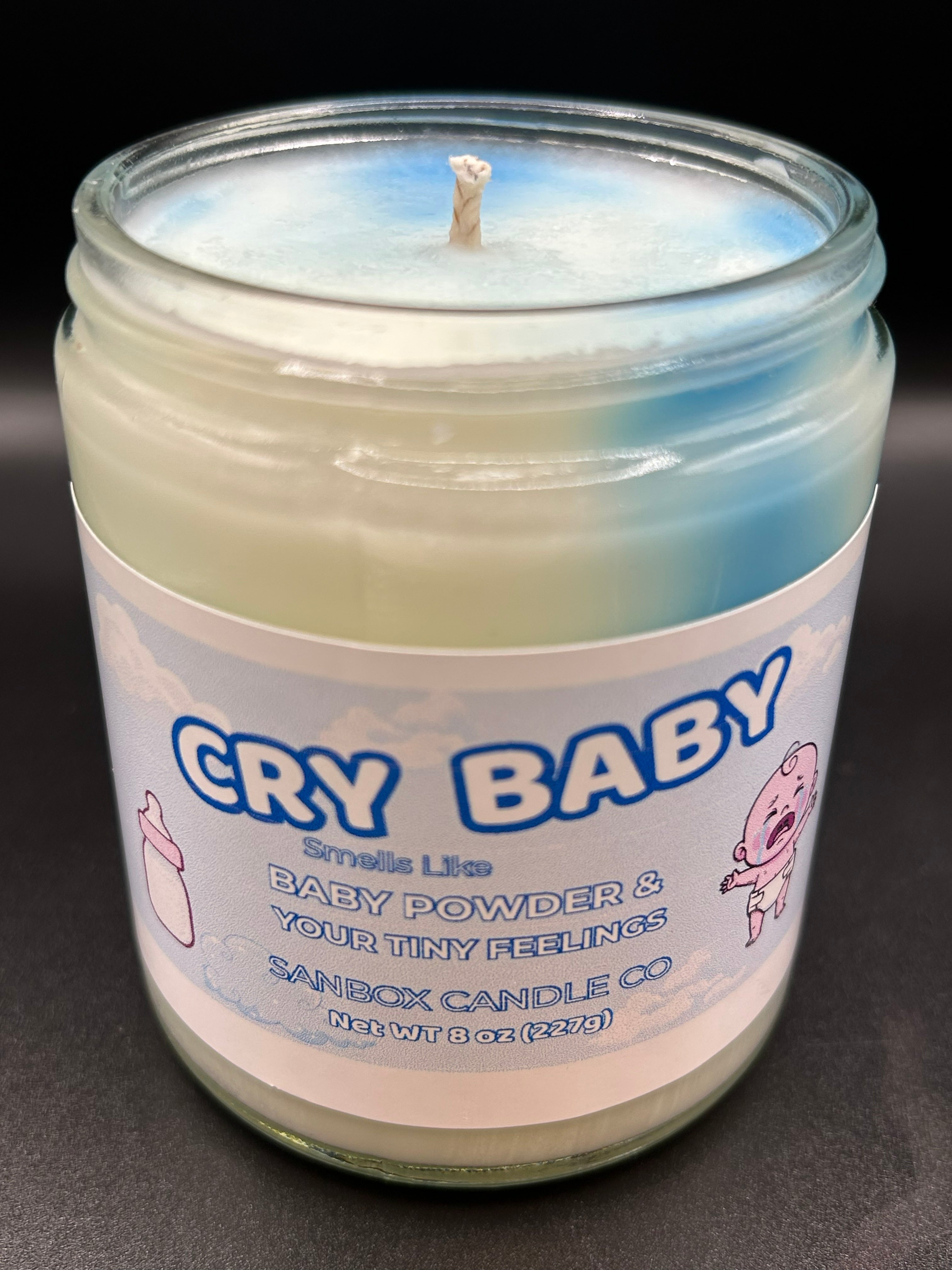 Hand-poured scented candle in glass jar labeled Cry Baby, baby powder fragrance, 8oz size
