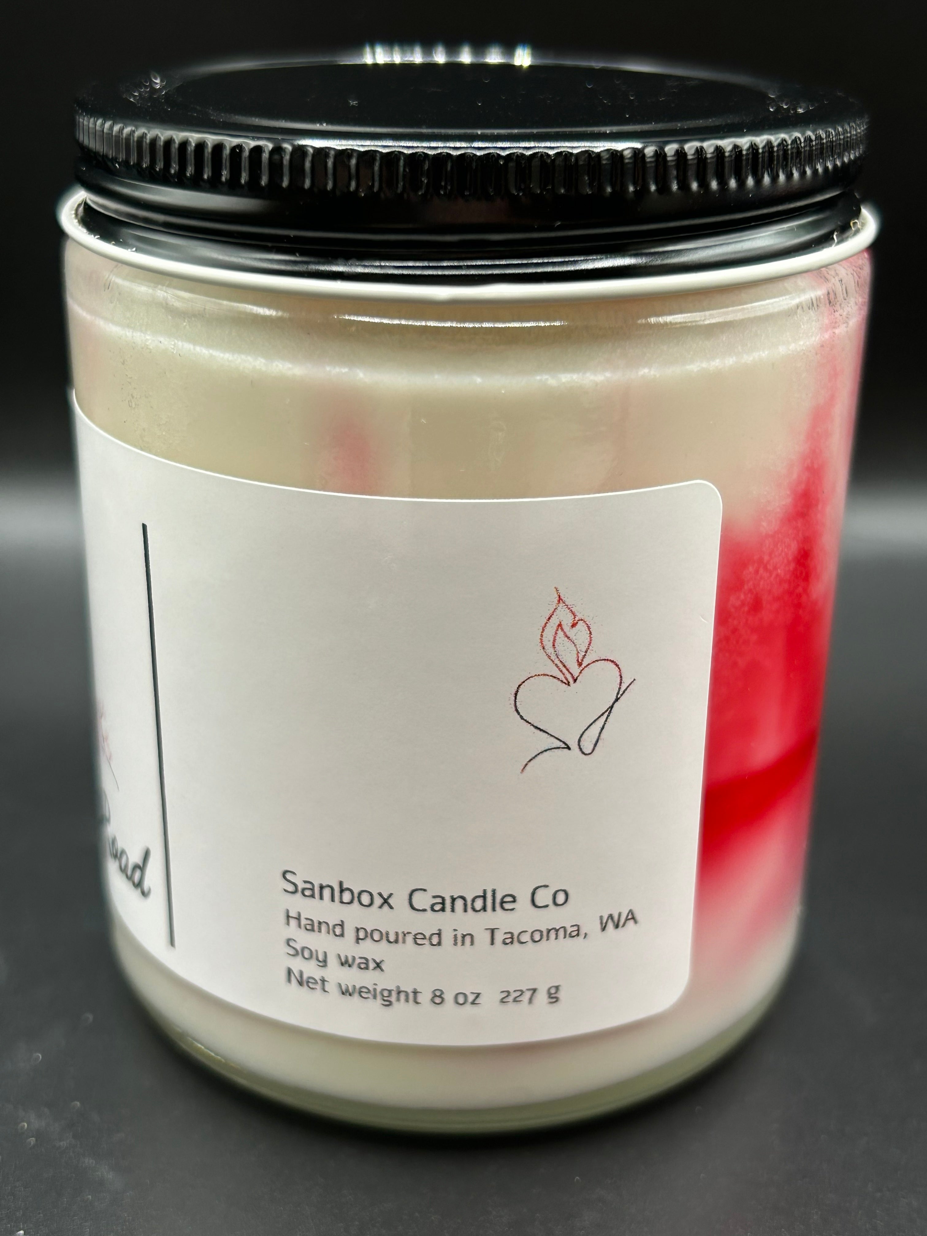 8oz hand-poured soy wax candle in glass jar with black lid and red-white swirl design label