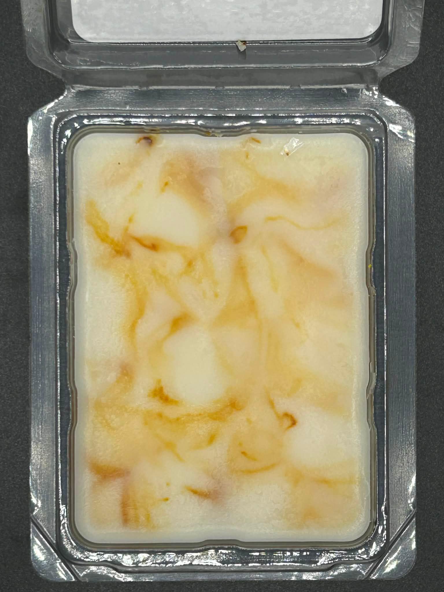 Hand-poured soy wax melt in clamshell packaging with creamy and brown marbled swirls