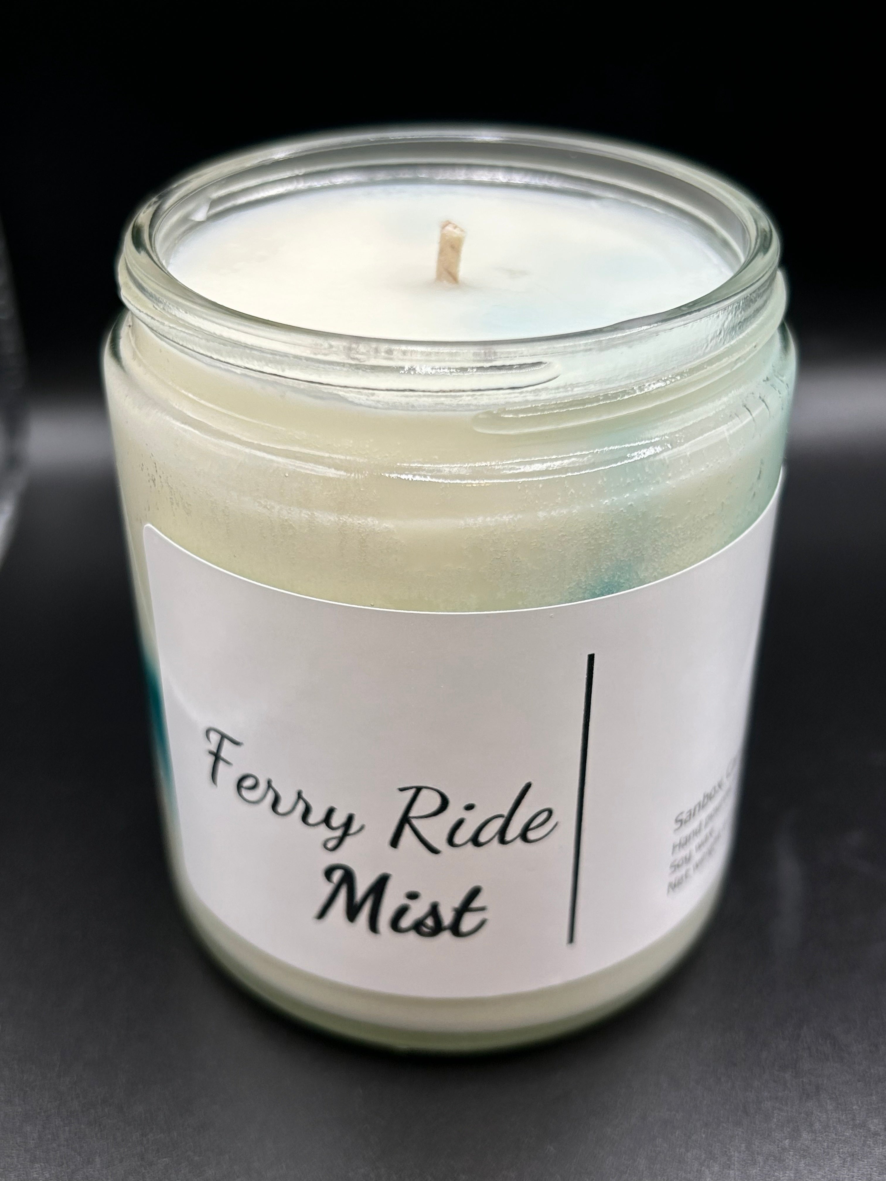 Ferry Ride Mist scented candle in clear glass jar with white wax, black background