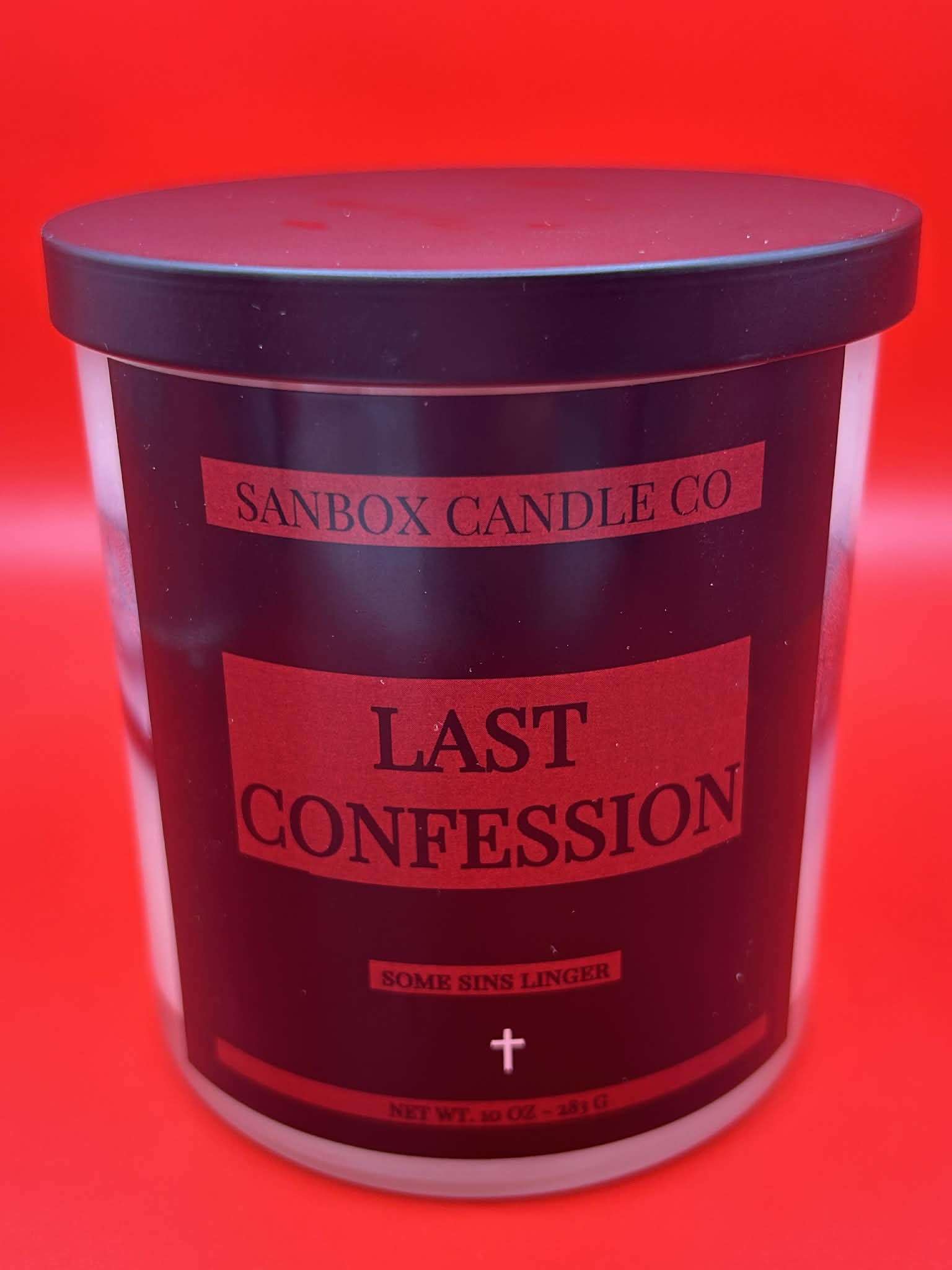 Black jar candle labeled 'Last Confession' with red and black design on red background