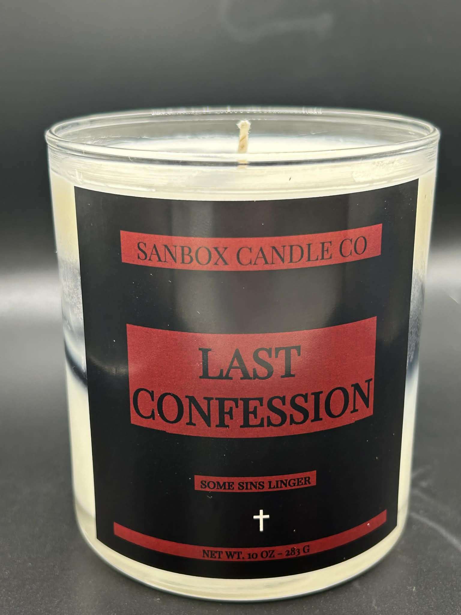 Hand-poured 10oz Last Confession scented candle in glass jar with black and red label.