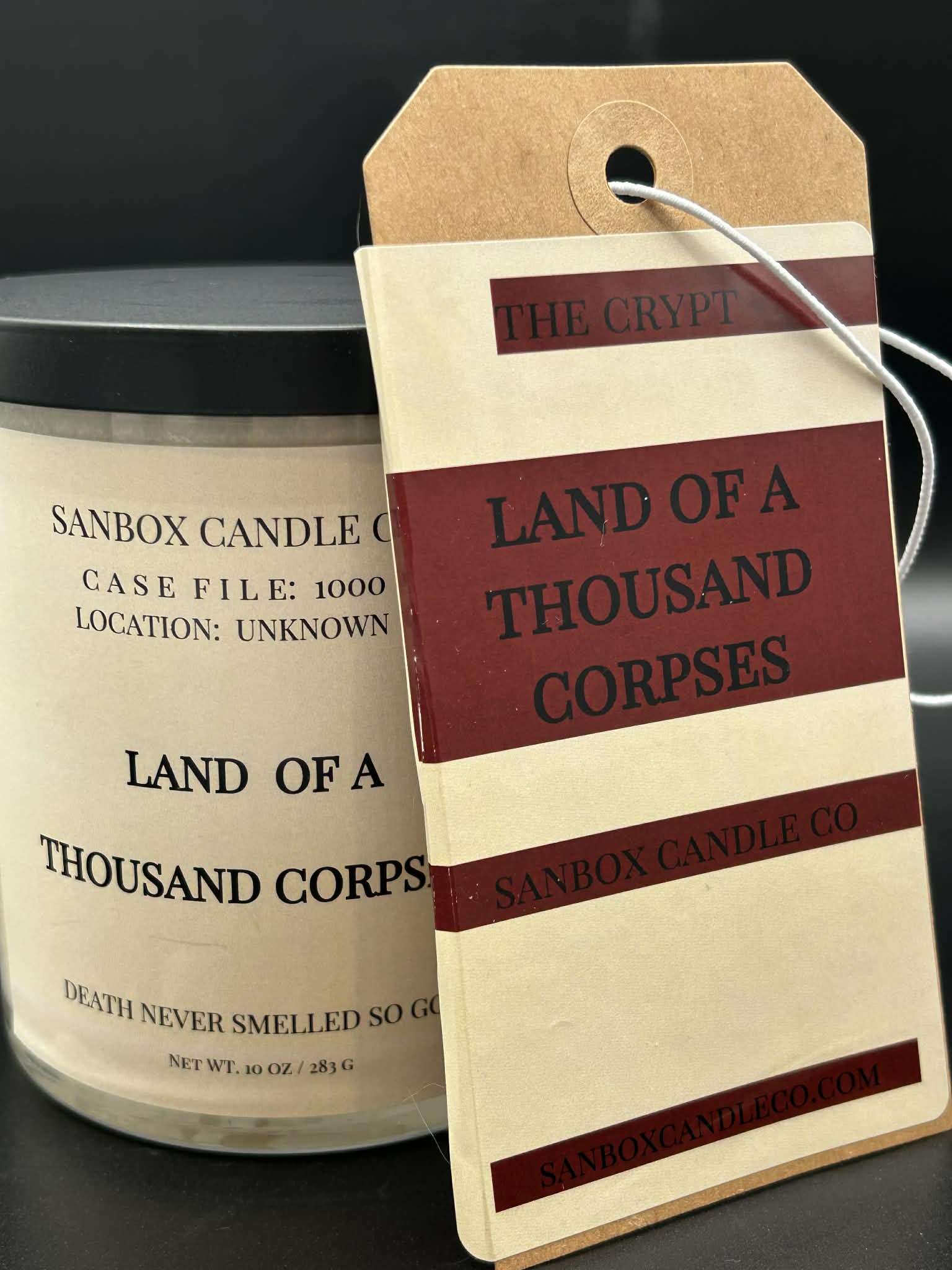 Land of a Thousand Corpses scented candle with brown tag and black lid, 10oz size.
