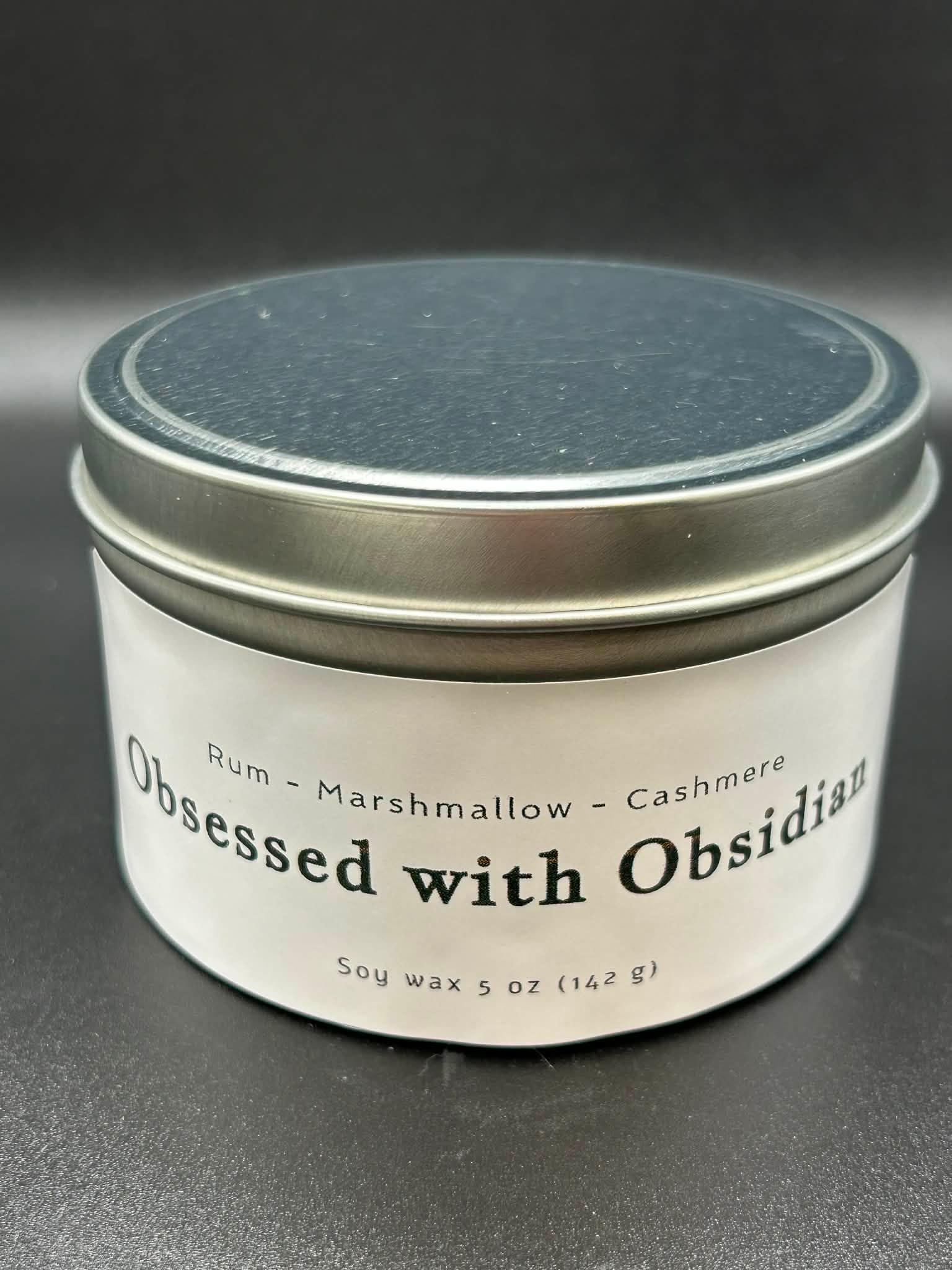 Obsessed with Obsidian soy wax scented candle tin, 5oz, with rum, marshmallow, cashmere notes.
