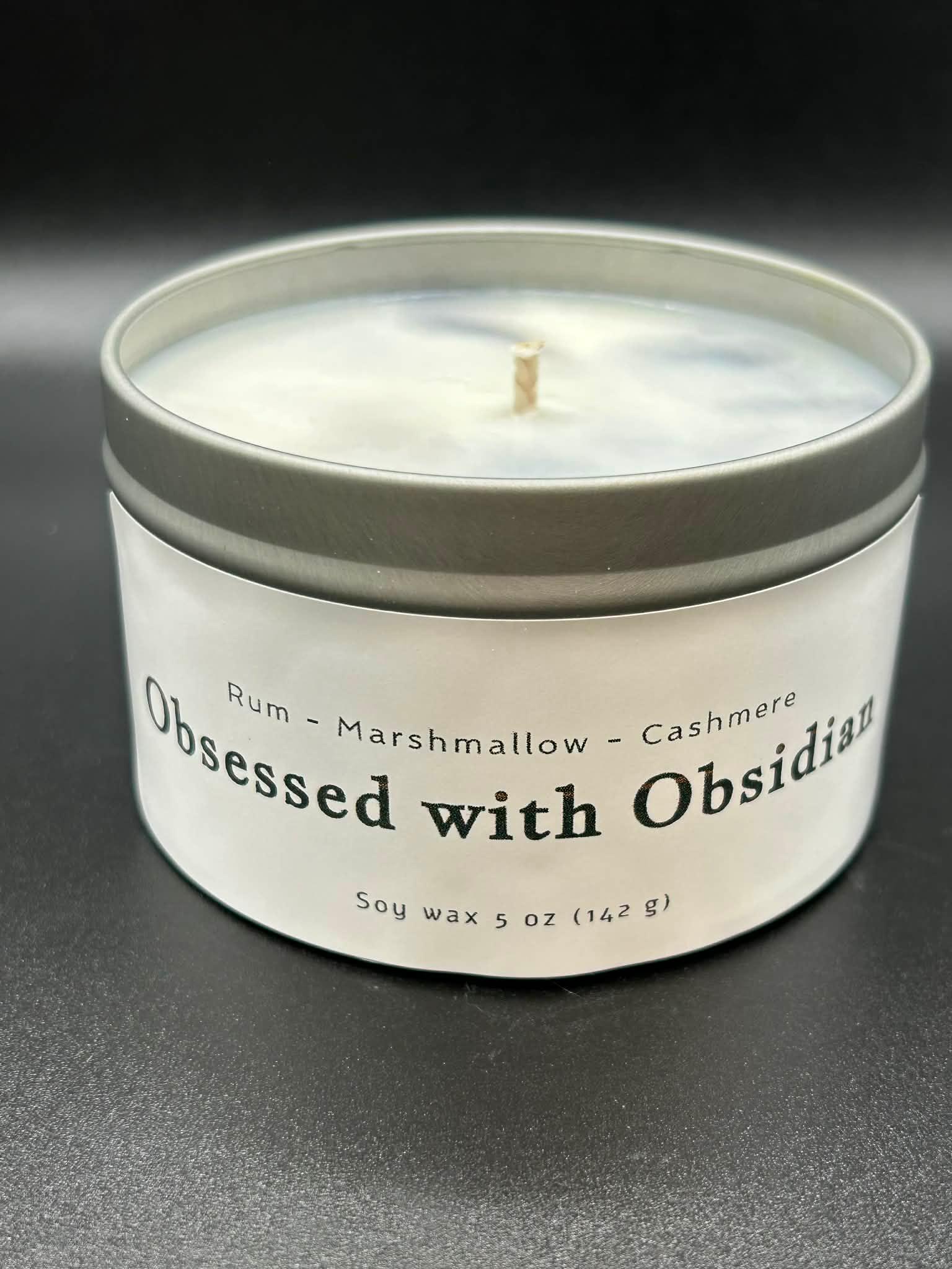 5oz soy wax candle in tin labeled 'Obsessed with Obsidian' with rum, marshmallow, cashmere scent