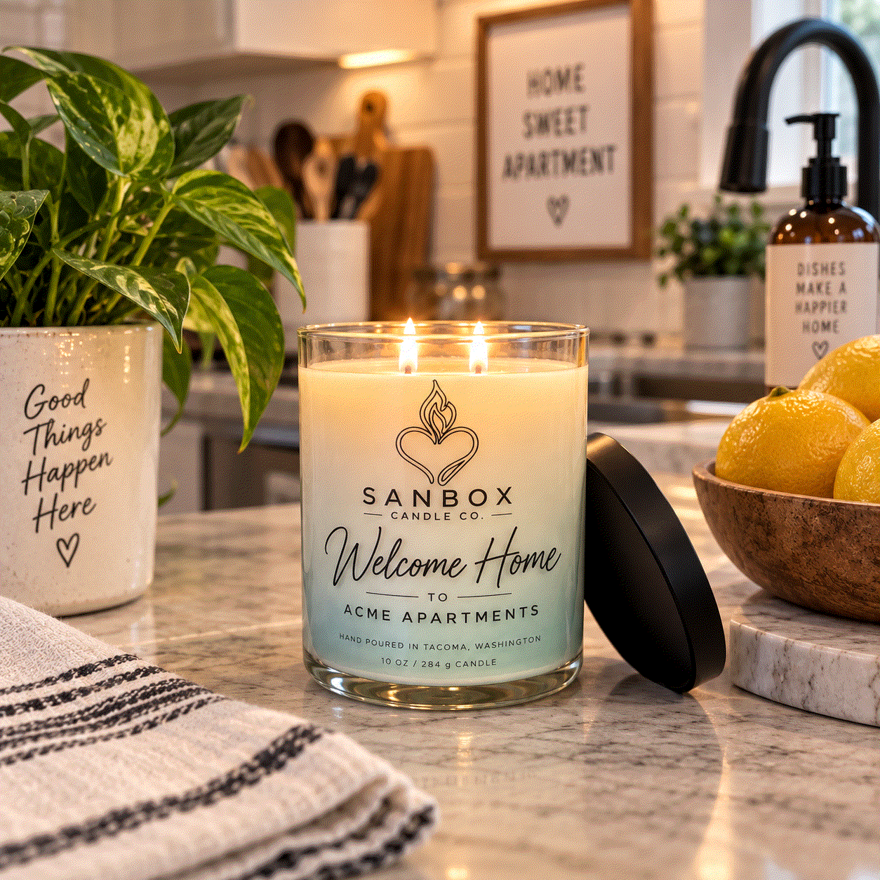 Welcome Home realtor gift candle in a clear glass jar with a matte black lid, cream soy wax with purple marbled design, styled on a marble side table.