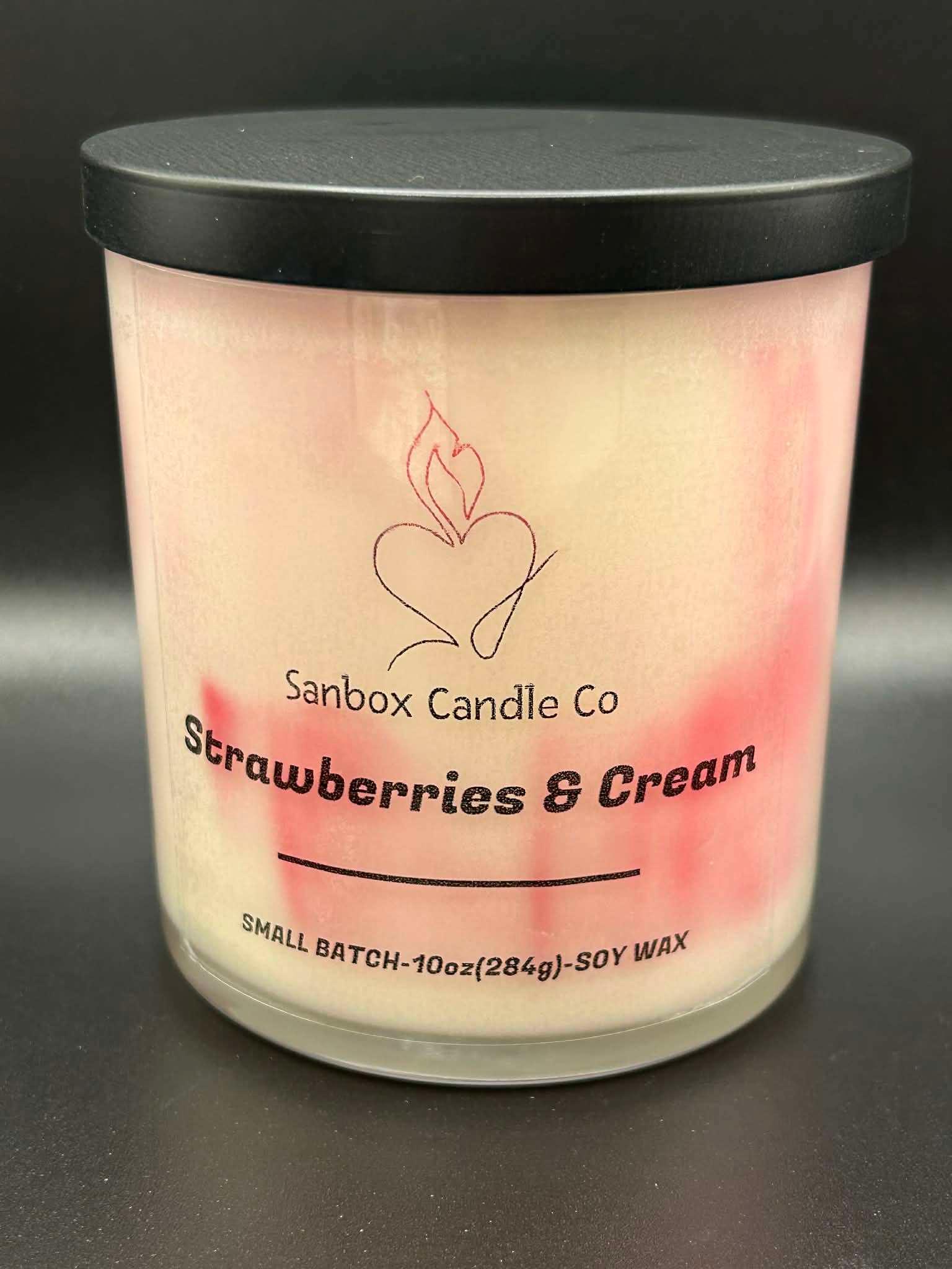 Strawberries & Cream scented soy candle, 10oz glass jar with pink swirls and black lid.
