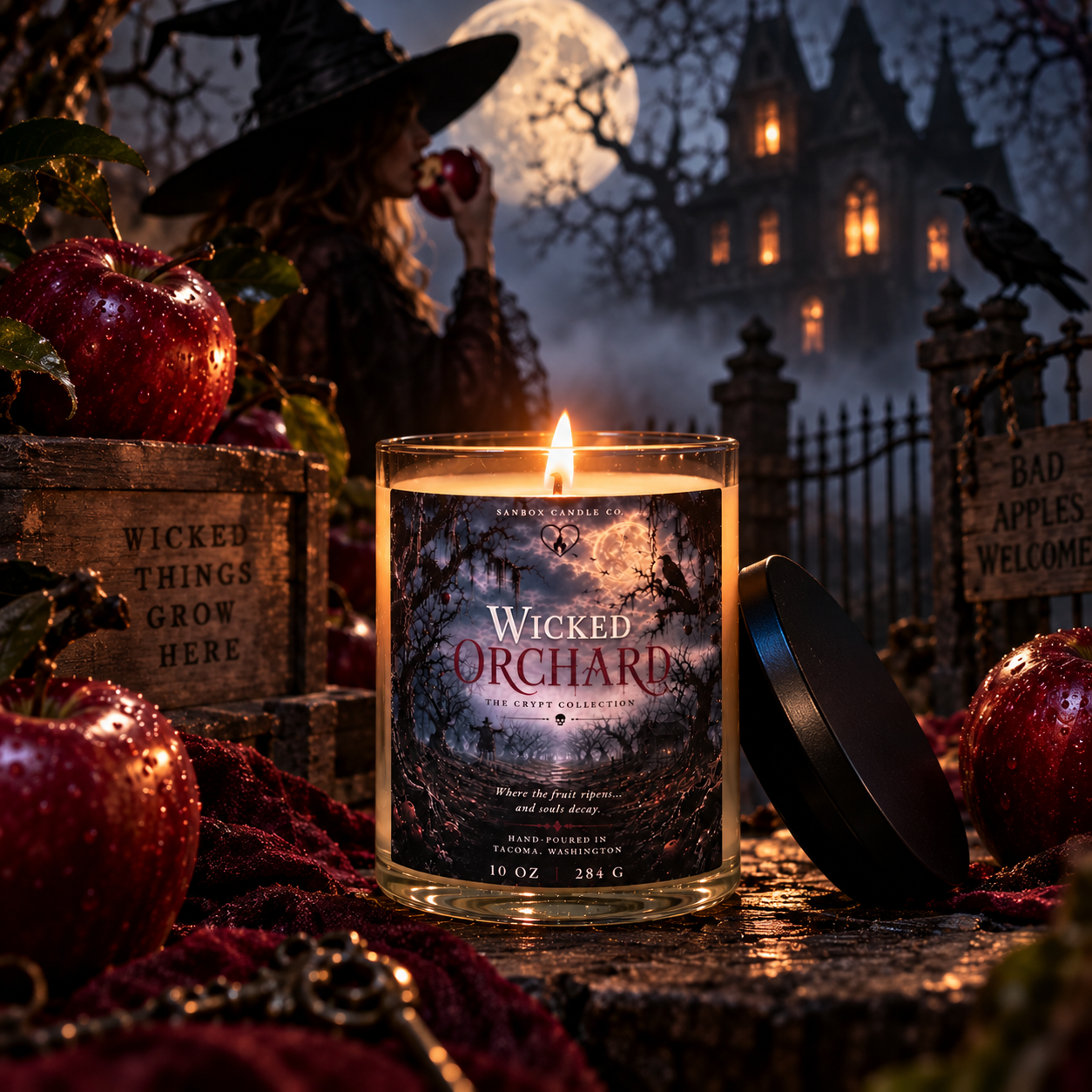 Wicked Orchard 10 oz apple amber soy candle burning in a clear glass jar with a black lid, surrounded by red apples, a skull, a raven, and vintage spell books in a gothic Halloween scene