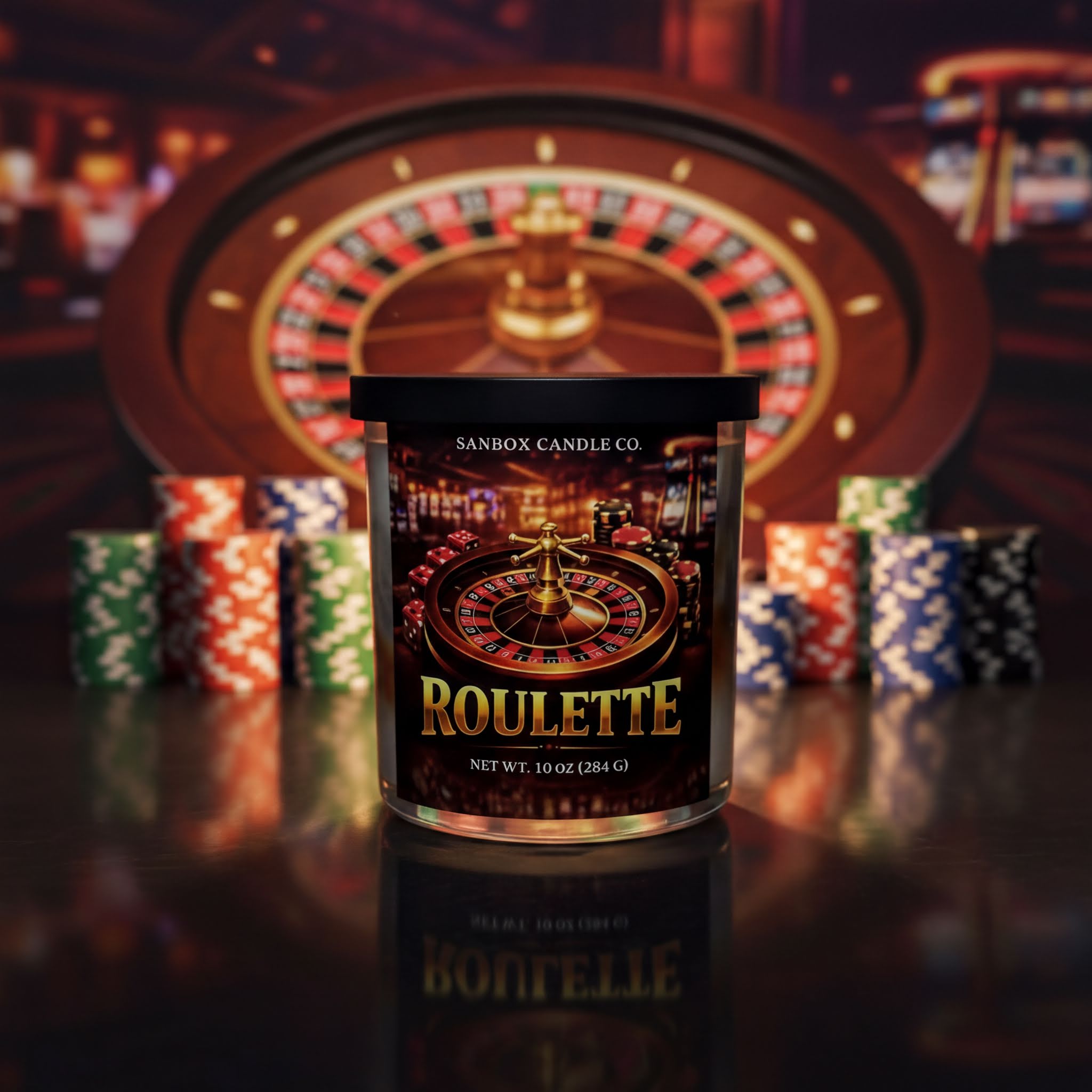 A roulette candle in a clear container with a label that reads "ROULETTE" and "NET WT. 10 OZ (284 G)" is placed in front of a roulette wheel and poker chips.