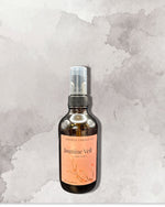 A bottle of "Jasmine Veil" room spray against a textured gray background.