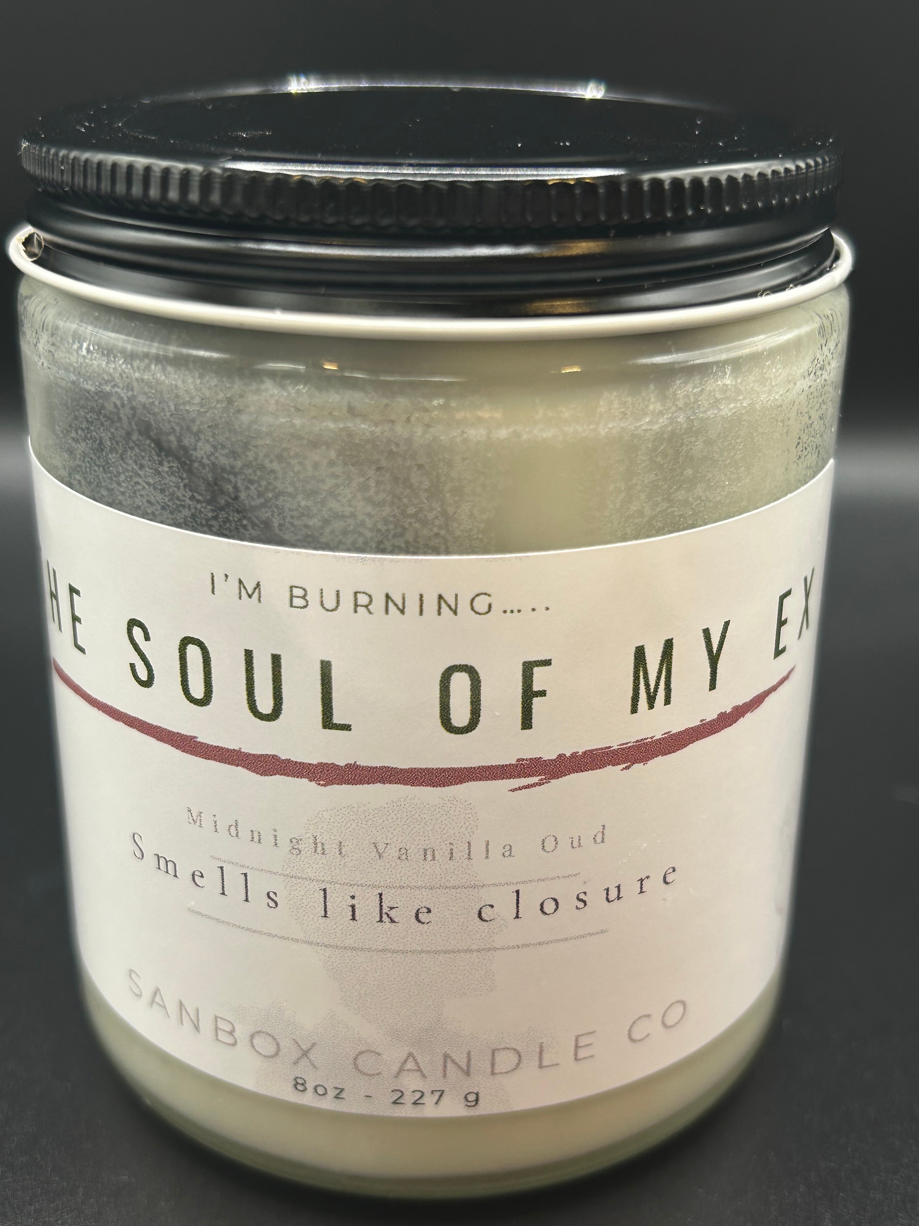 Hand-poured scented candle in glass jar labeled 'The Soul Of My Ex,' 8oz Midnight Vanilla Oud.